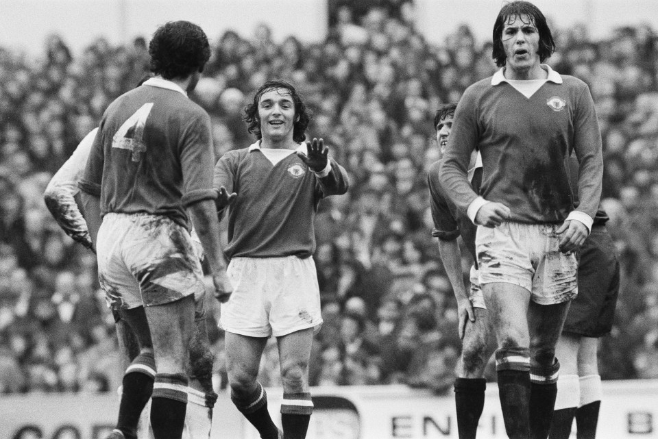 Black and white photo of Manchester United soccer players celebrating a goal.