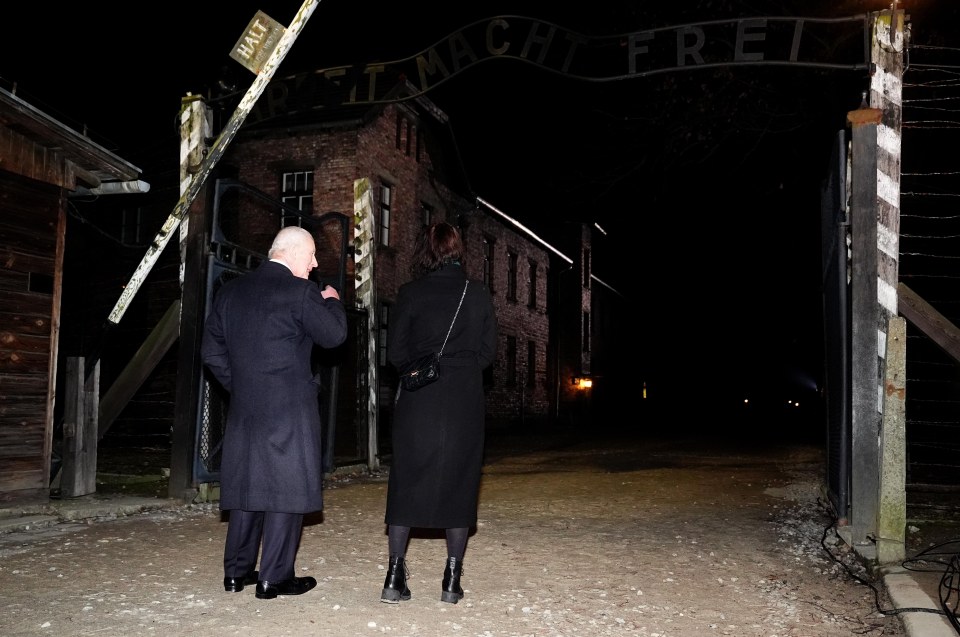 King Charles III touring Auschwitz-Birkenau at night.