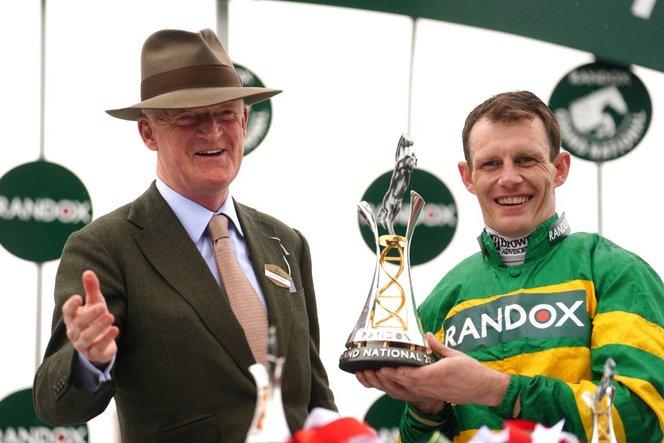 Trainer Willie Mullins and jockey Paul Townend with a trophy after a horse race.