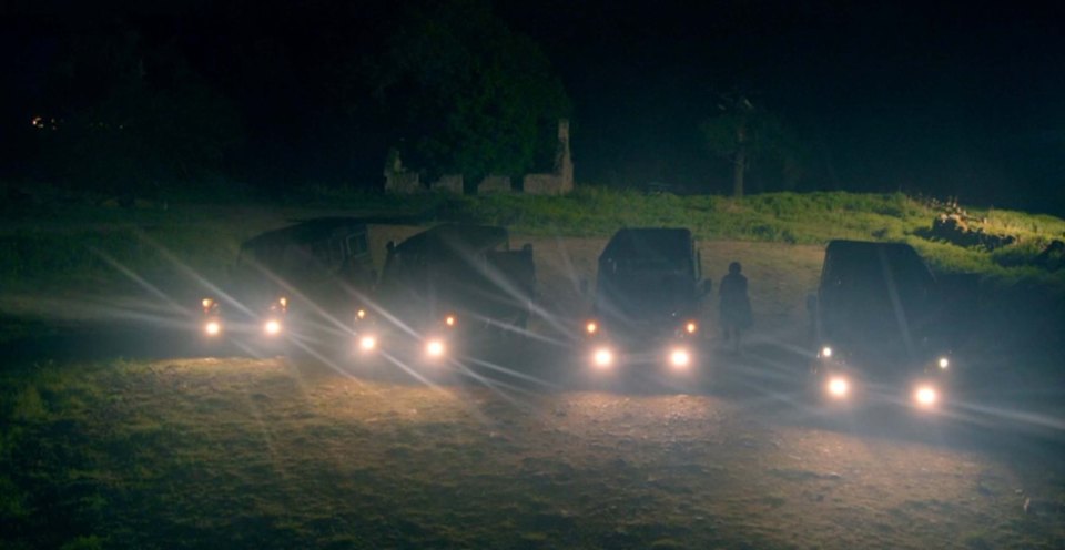 Four vehicles parked at night.