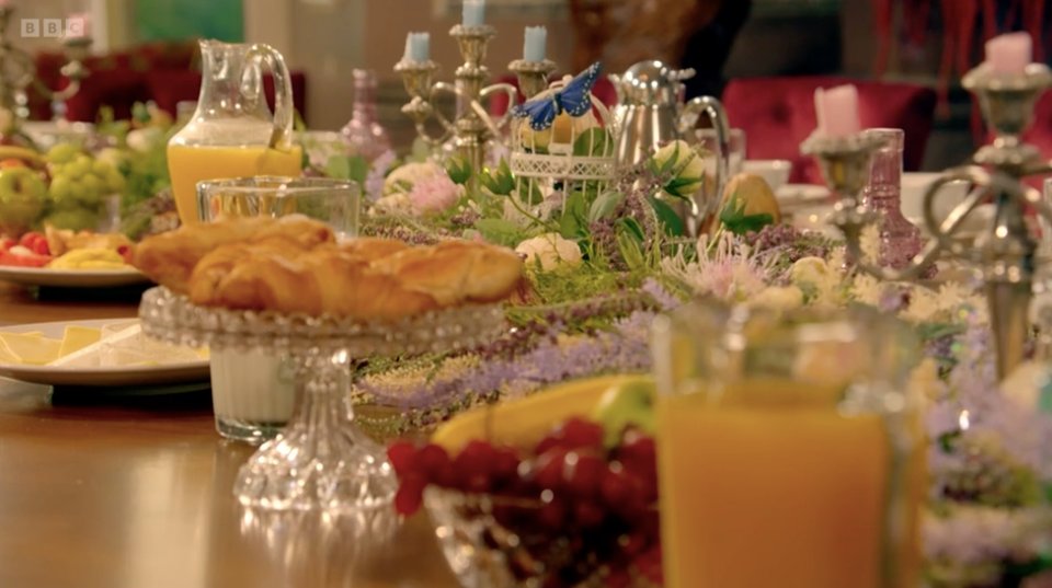 A lavish breakfast table spread with pastries, fruit, and juice.