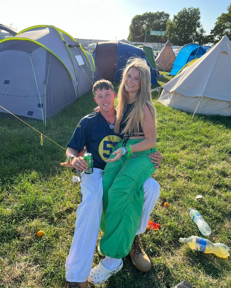 Couple sitting together at a festival campsite.