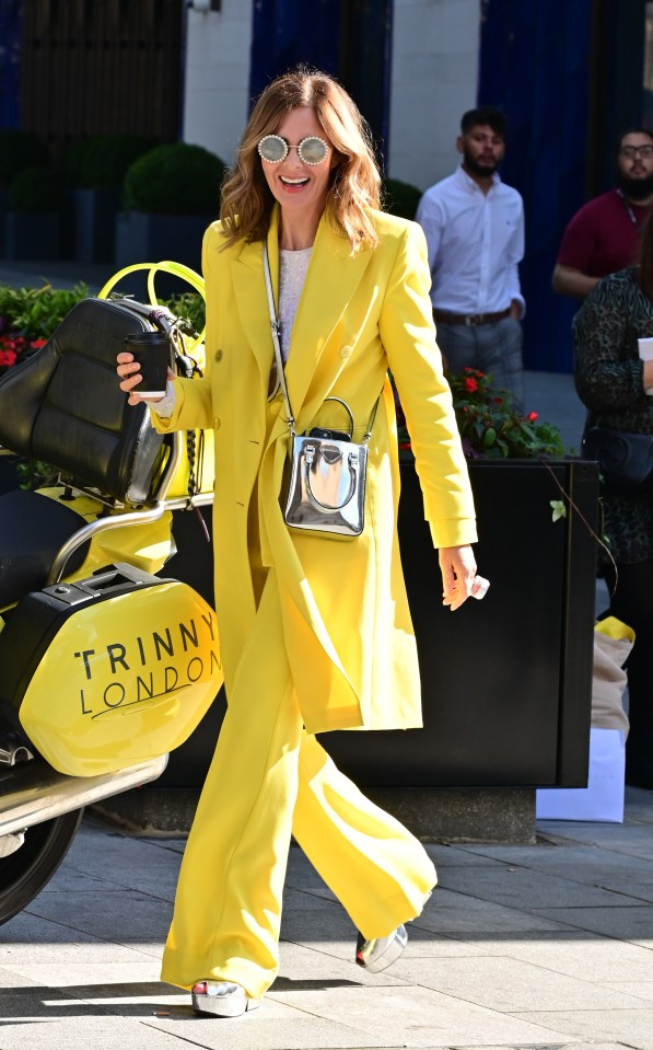 Trinny Woodall in a yellow suit walking in London.