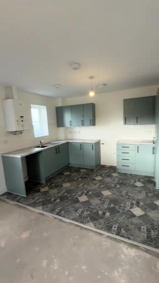 A teal kitchen in a council house.