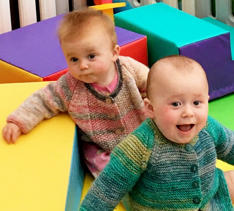 Twin babies, Eloise and Eddie Wood, wearing knitted cardigans.