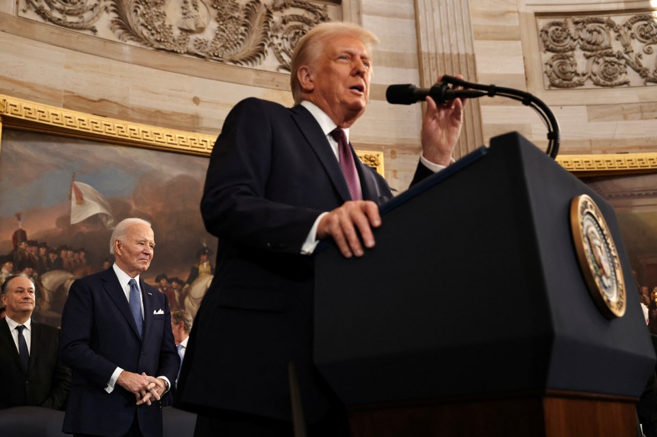 President Donald Trump speaking at a podium, with President Joe Biden standing behind him.