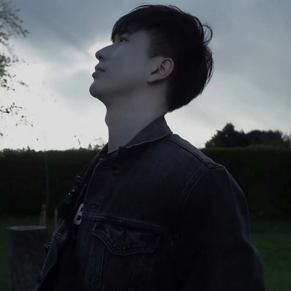 Man looking up, wearing a dark denim jacket.