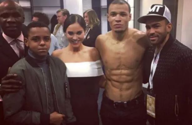 Group photo of Chris Eubank Jr. shirtless with Vicki Pattison, a young boy, and another man.