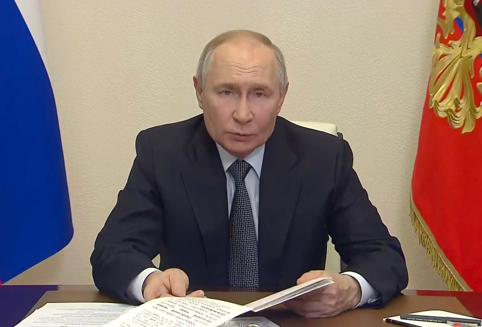 Vladimir Putin reading a document at a government meeting.