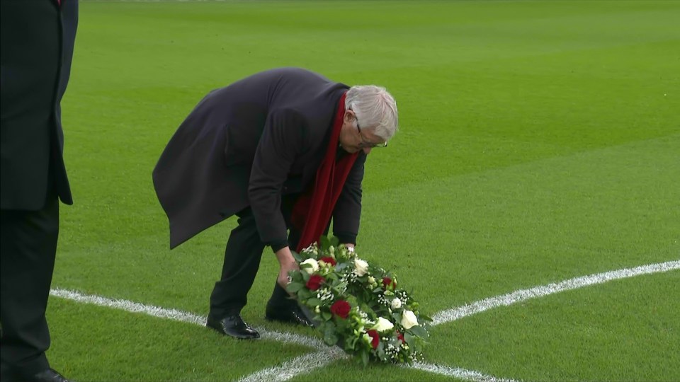 Man placing wreath on soccer field.