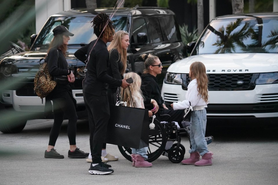 Anna Kournikova in a wheelchair with her family during a shopping trip.