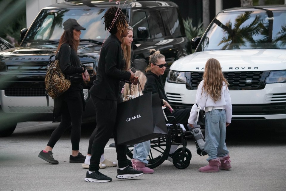 Anna Kournikova in a wheelchair with her family during a shopping trip.