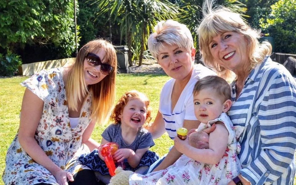 A group of women and two young girls in a garden.