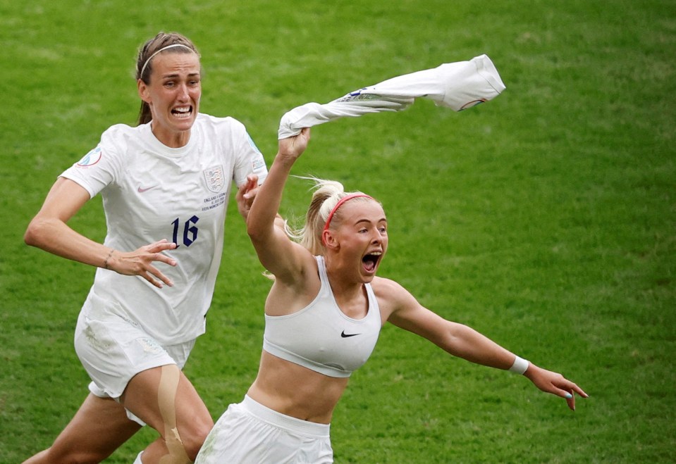 Two England soccer players celebrating a goal at Wembley Stadium.