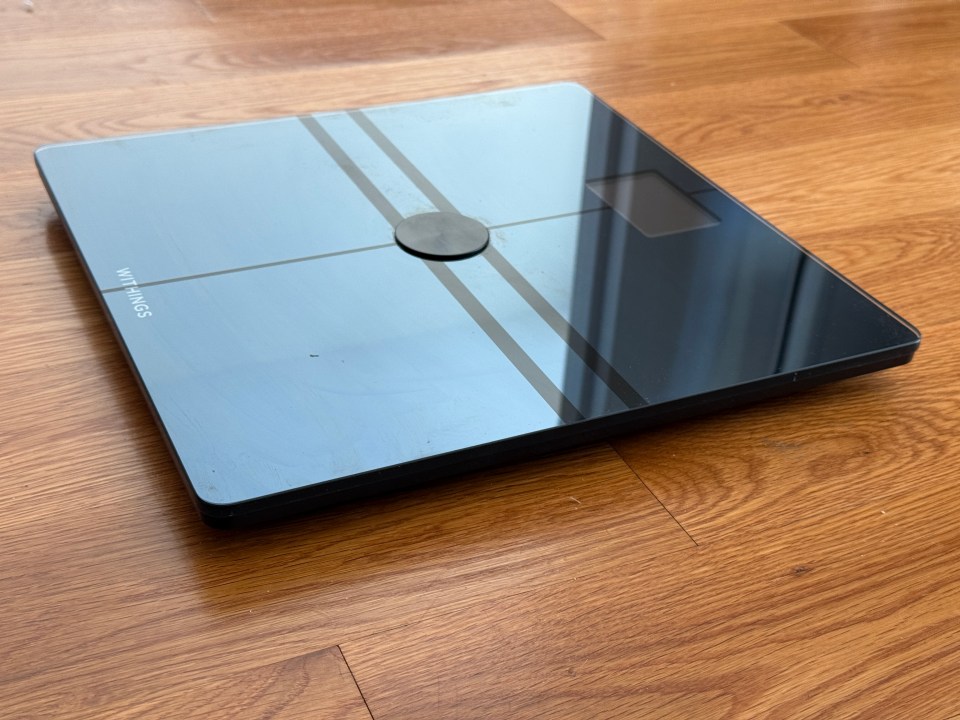 Withings smart scale on a wooden floor.