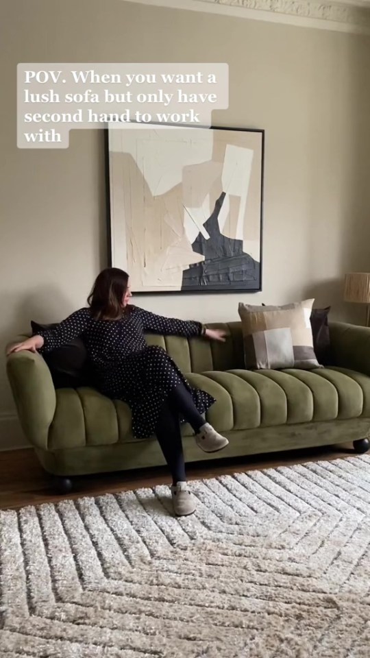 Woman sitting on a refurbished green velvet sofa.