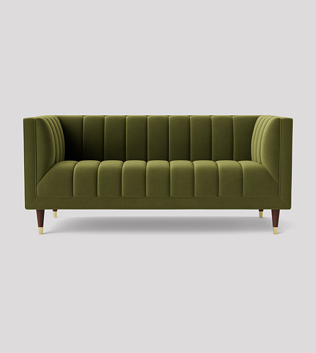 Woman sitting on a refurbished olive green sofa.