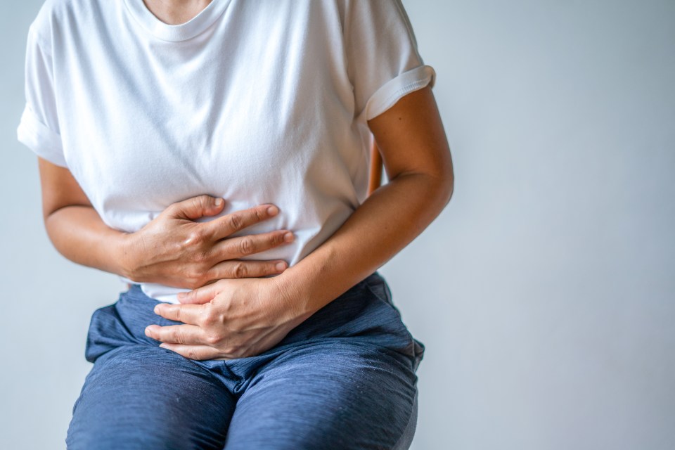 Woman holding her abdomen in pain.