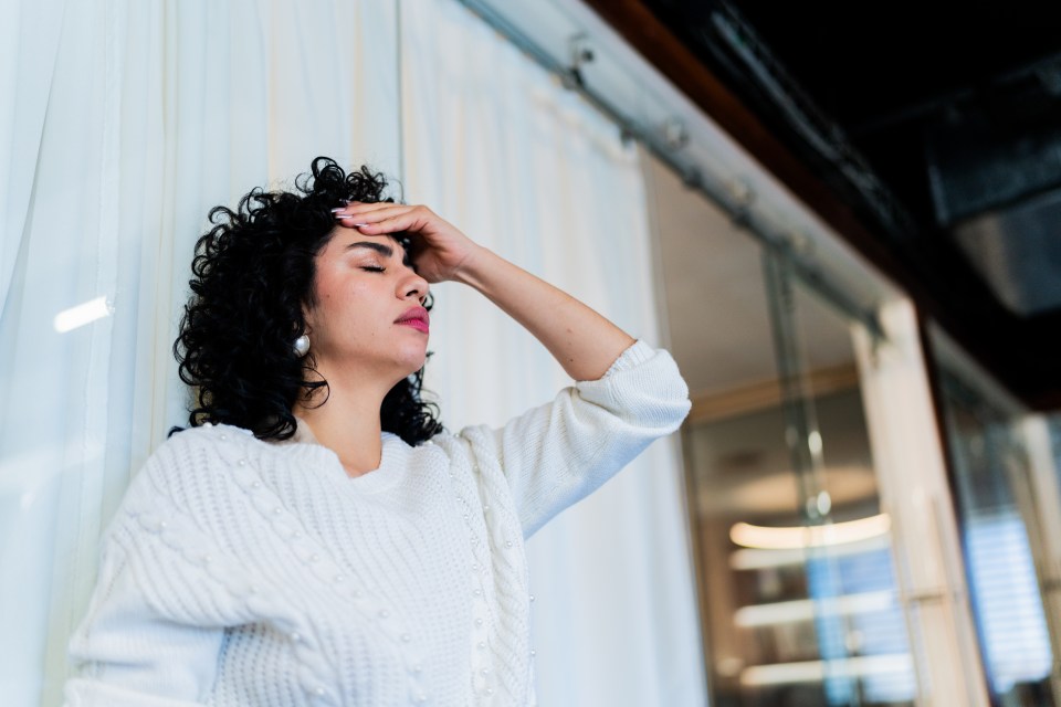 Worried businesswoman holding her head in an office.