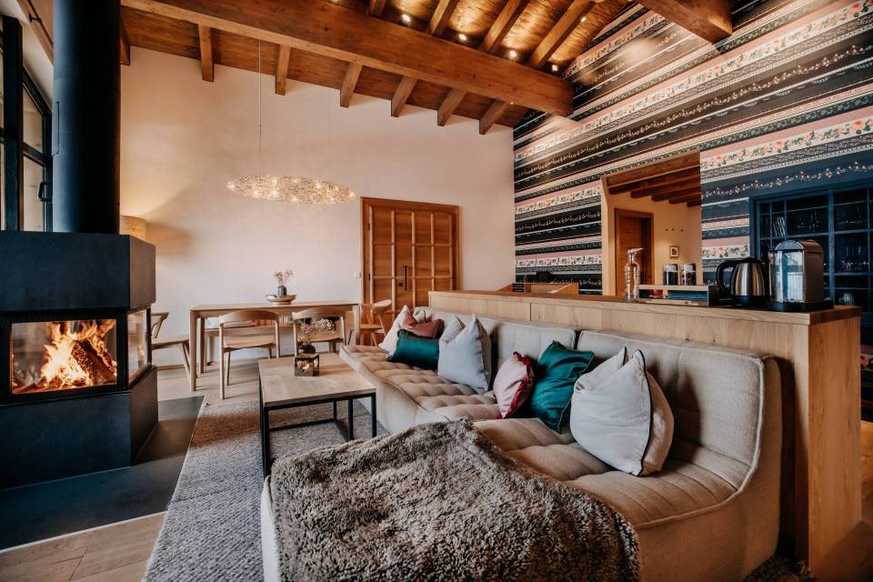 Living room with fireplace, sectional sofa, and patterned wall.