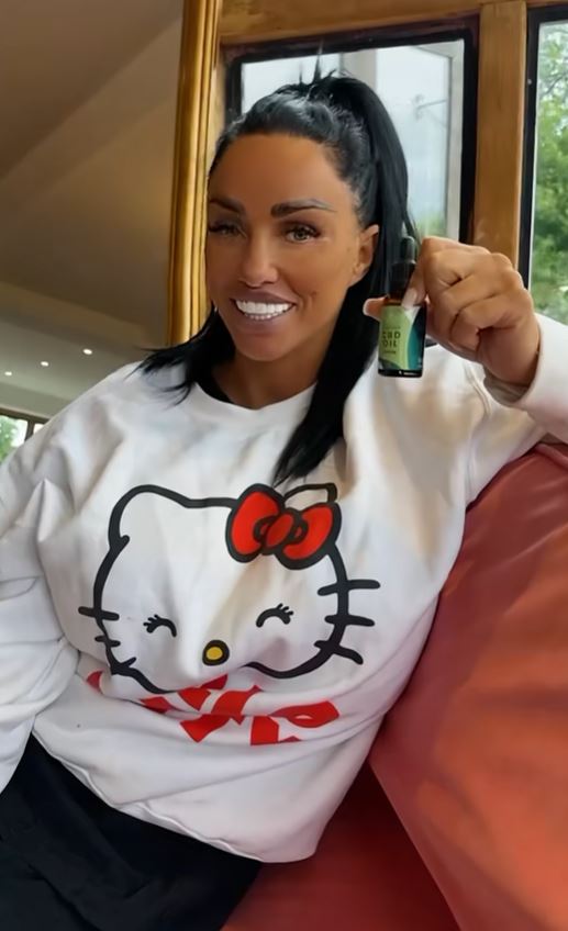 Katie Price holding a CBD oil bottle.