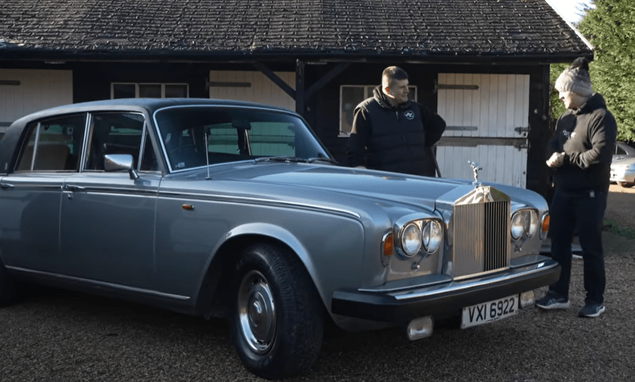 Silver Rolls-Royce Silver Shadow with two men standing beside it.