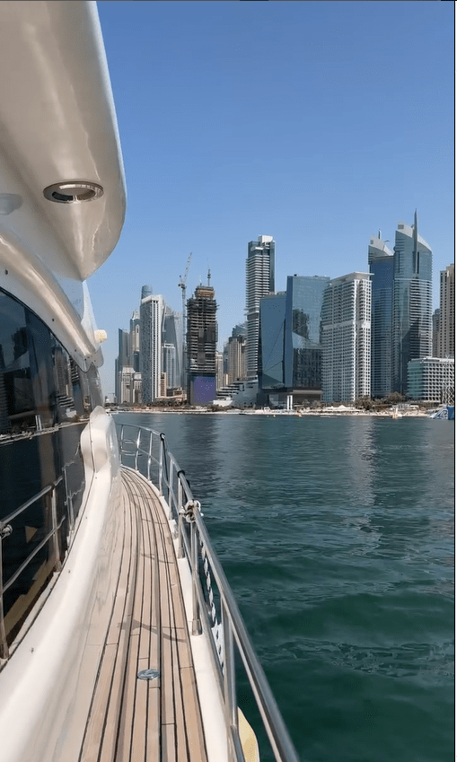 Yacht sailing past a city skyline.