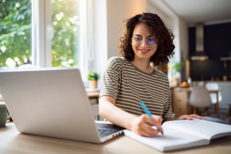 Smiling university student studying online at her desk.