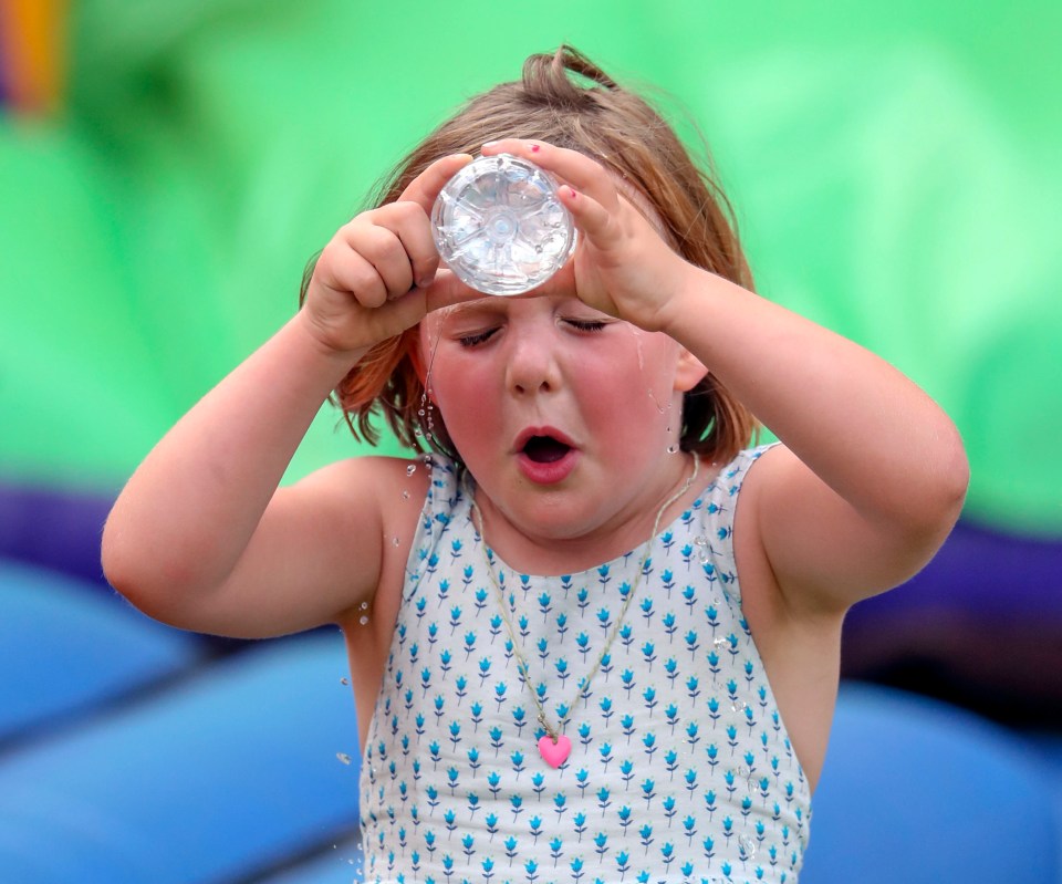 Girl pouring water on her face.