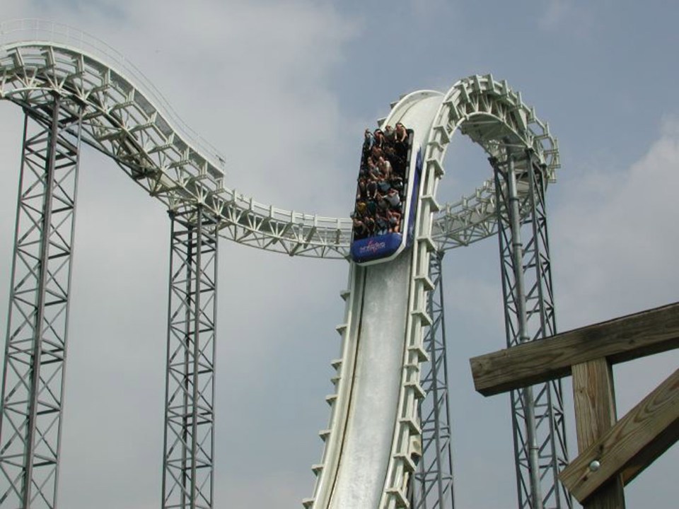 Rollercoaster riders ascending a large drop.