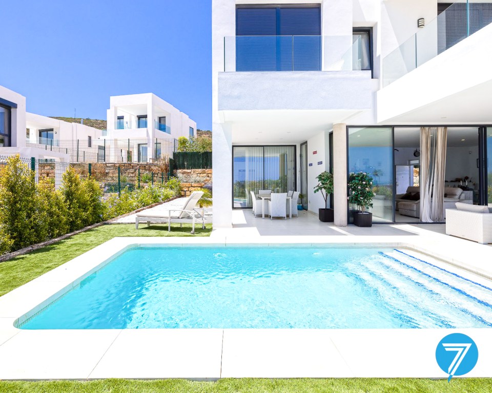 Modern white villa with a pool and patio.