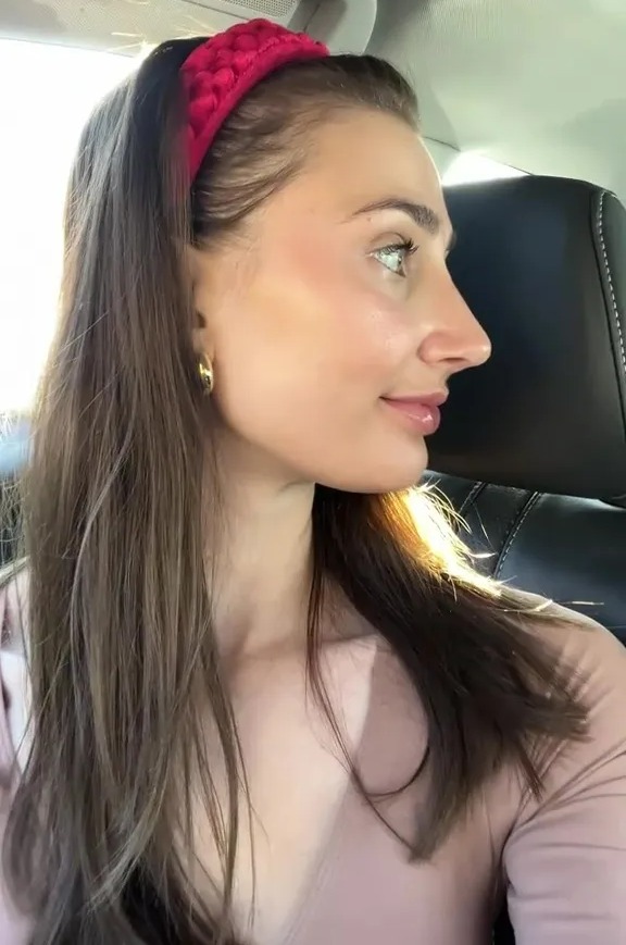 Woman in a car wearing a red headband.