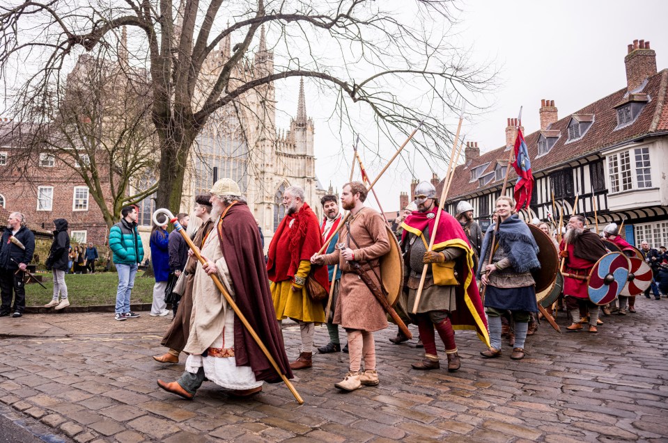 People in medieval costumes marching.