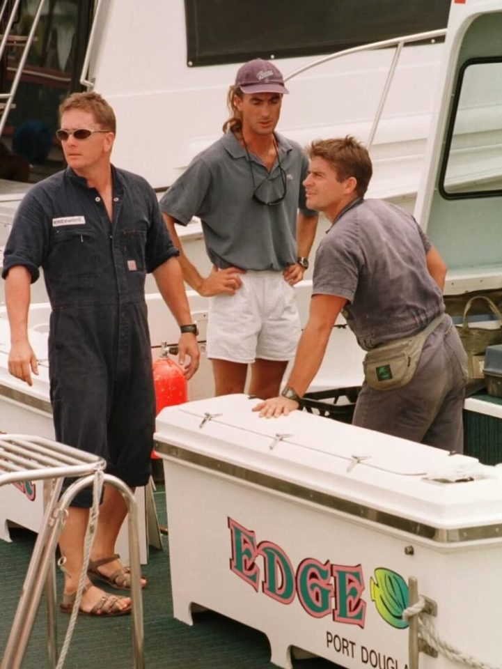 Three men on a boat, possibly crew members.