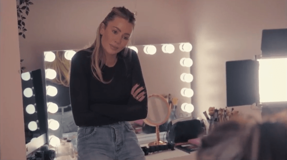 Woman with arms crossed in a makeup room.