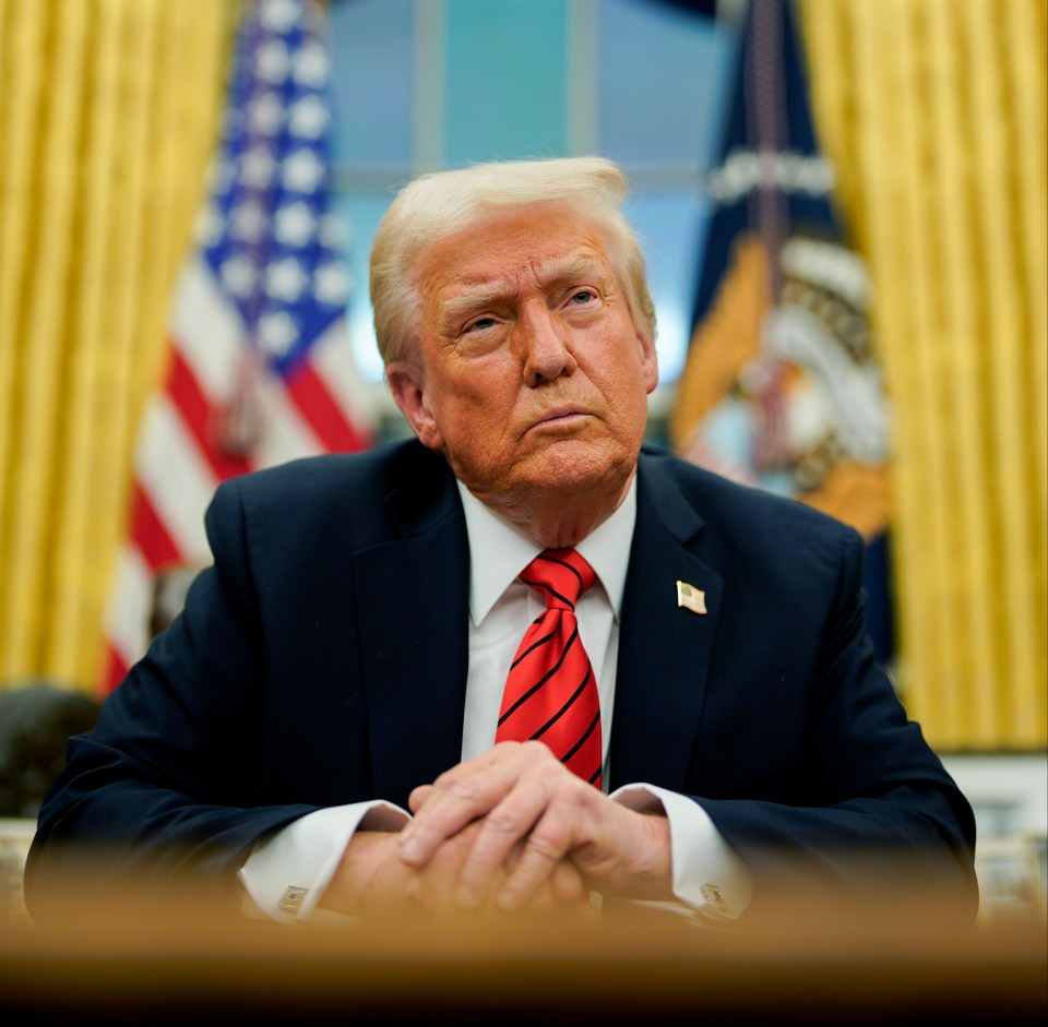 Donald Trump sitting at a desk in the Oval Office.