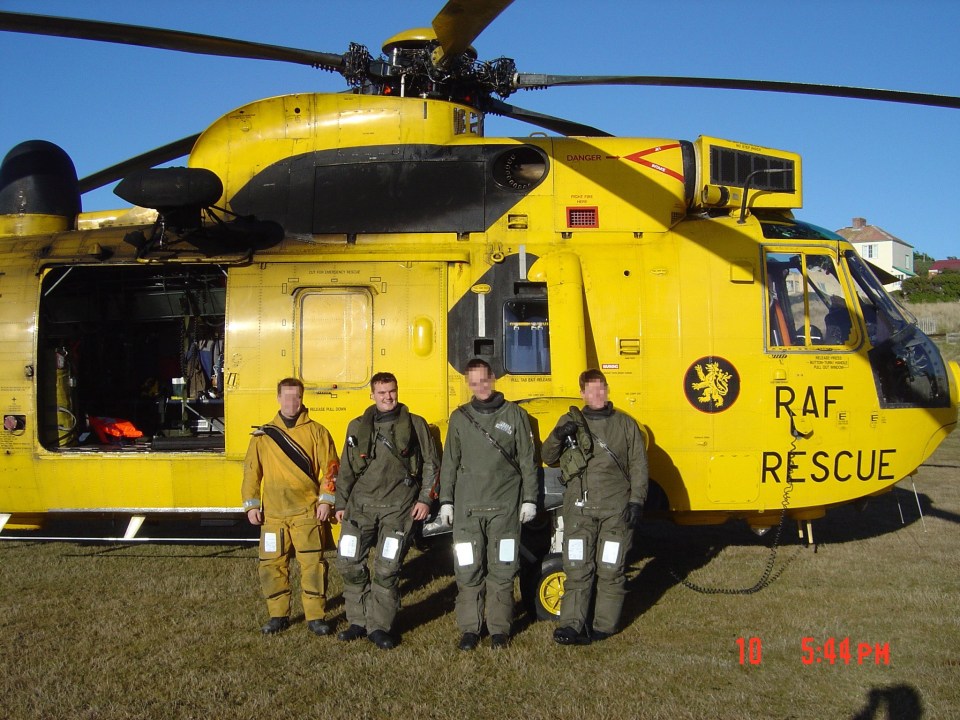 Four crew members stand in front of a yellow RAF rescue helicopter.