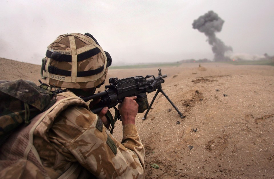 British soldier firing a machine gun during a battle in Afghanistan.