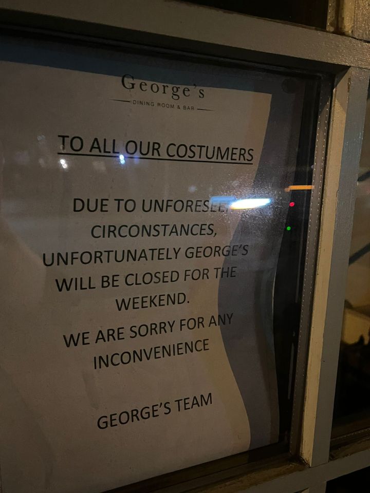 Sign on George's Dining Room & Bar door announcing temporary closure due to unforeseen circumstances.