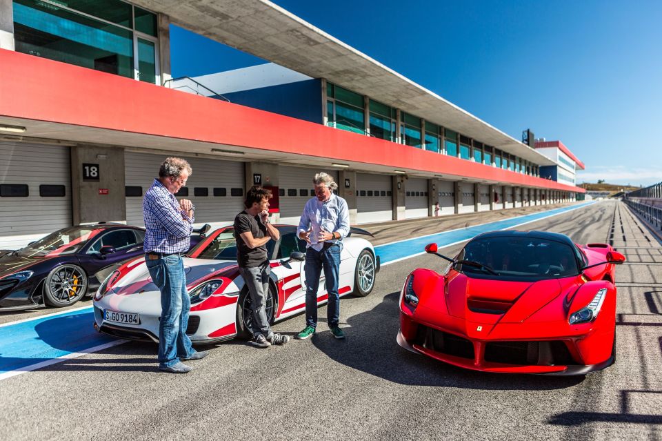 Jeremy Clarkson, Richard Hammond, and James May standing by sports cars.