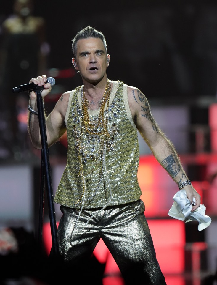 Robbie Williams performing on stage.