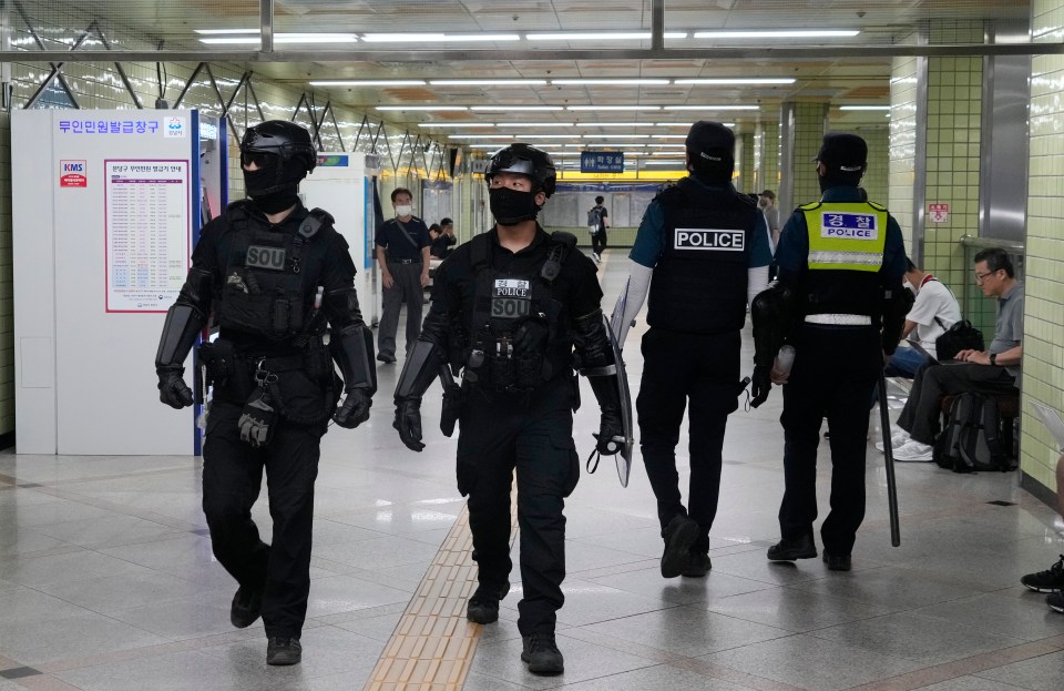 South Korean police officers patrolling a subway station.