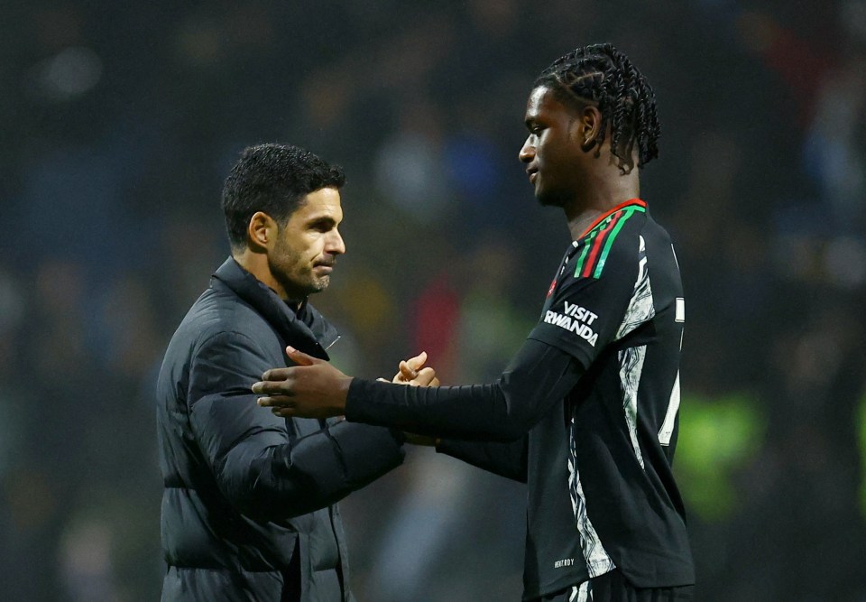 Mikel Arteta shaking hands with an Arsenal player.