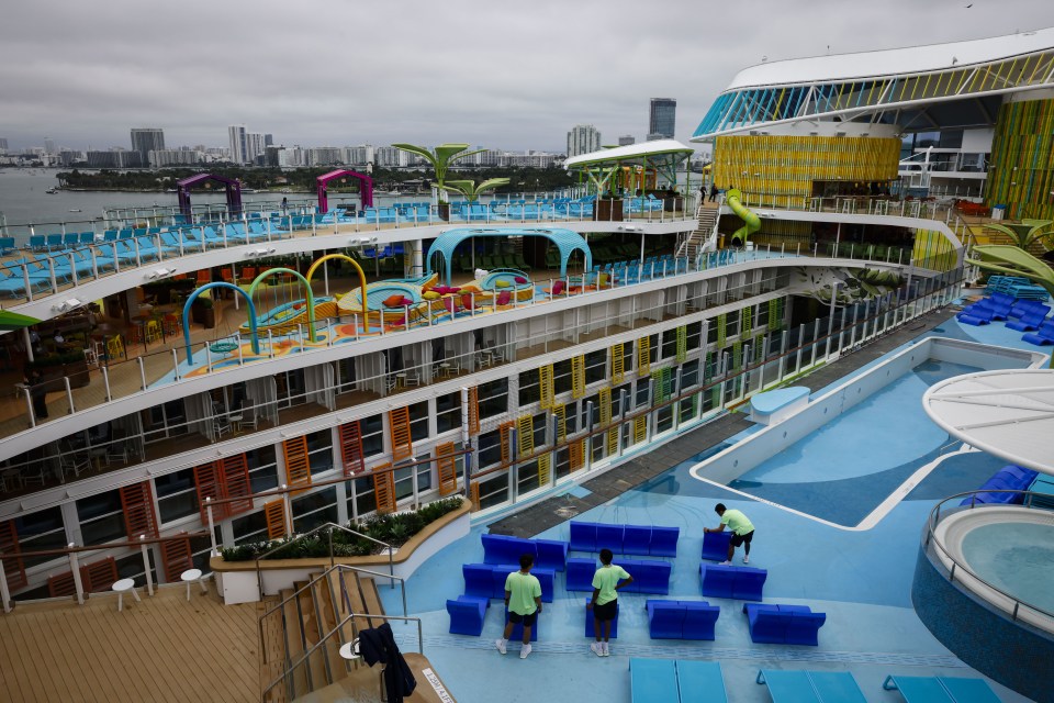 Workers arranging lounge chairs on the Icon of the Seas cruise ship.