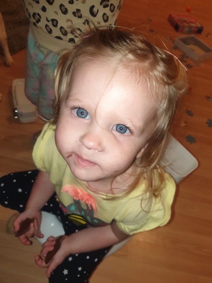 A five-year-old girl with blue eyes sitting down.