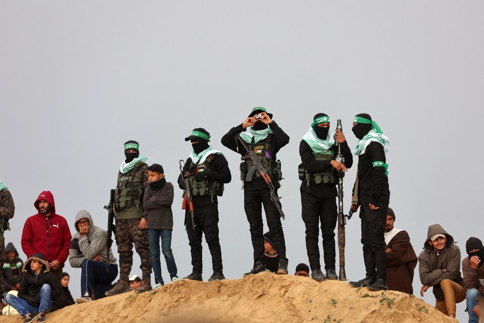 Hamas fighters stand guard during the handover of Israeli hostages' bodies.