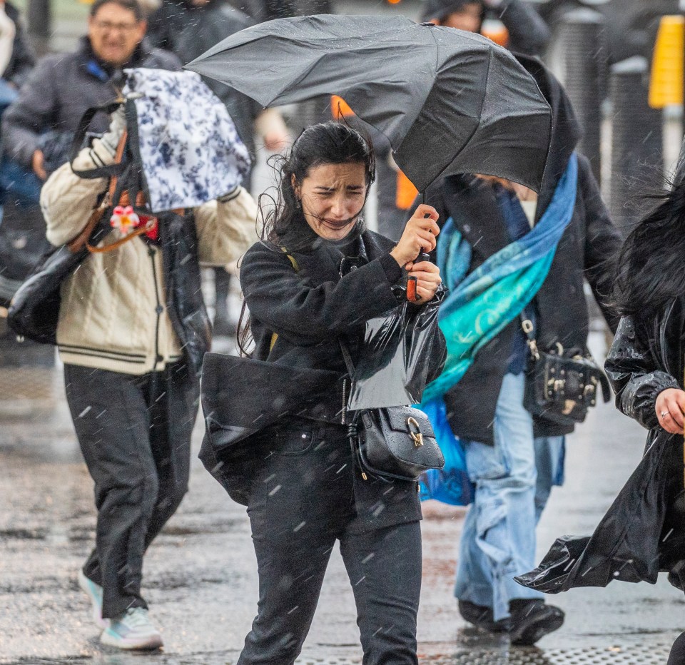 People battling strong winds and rain in London.