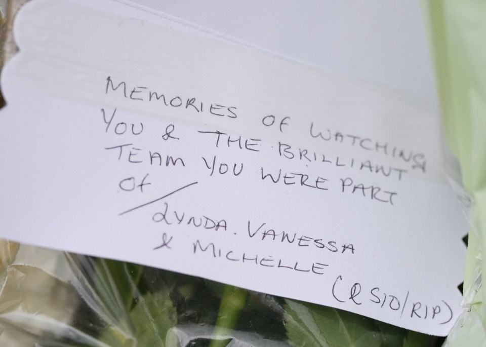 Handwritten tribute among flowers.