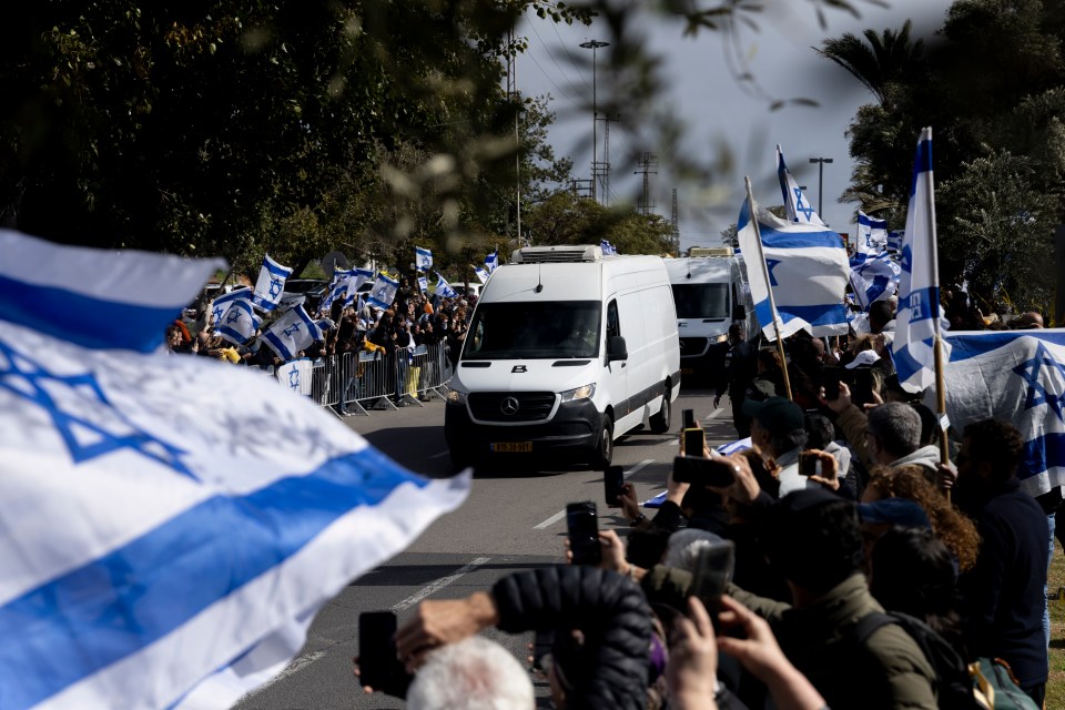 A convoy carrying the bodies of hostages arrives in Tel Aviv, greeted by mourners waving Israeli flags.