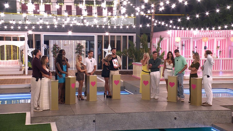 Love Island All Stars contestants gathered around a table.